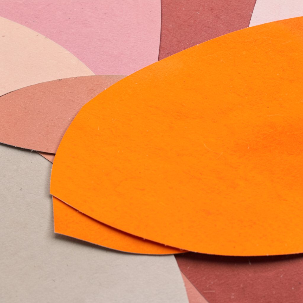 A small layered paper cut-out portrait silhouette in warm amber and cream tones, suggesting a student leader.